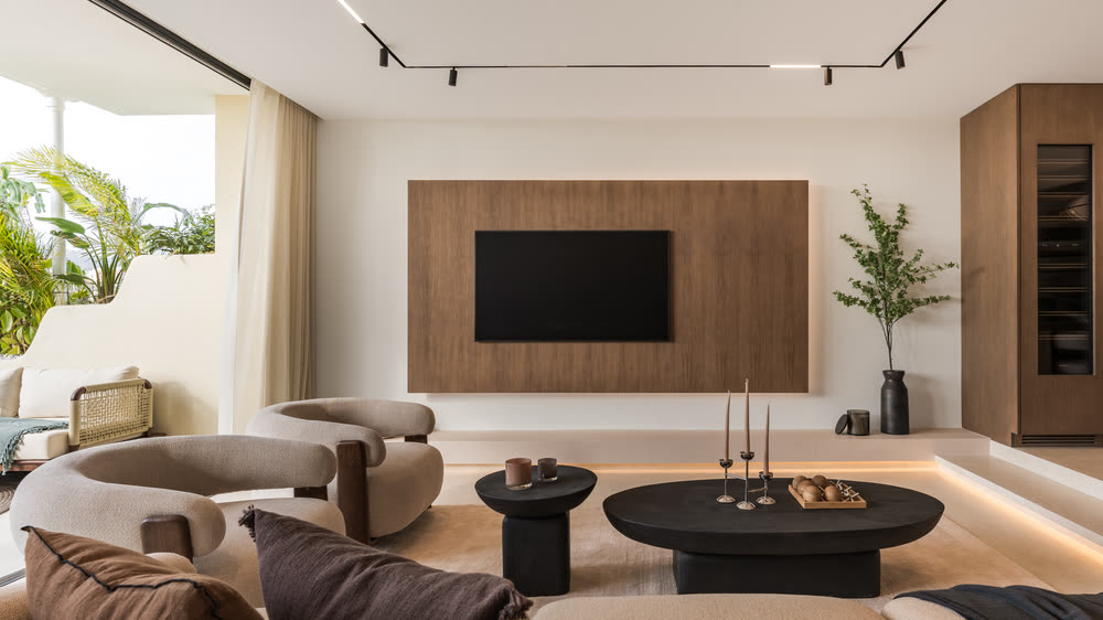 Bright living room with a curved sofa and oak media wall
