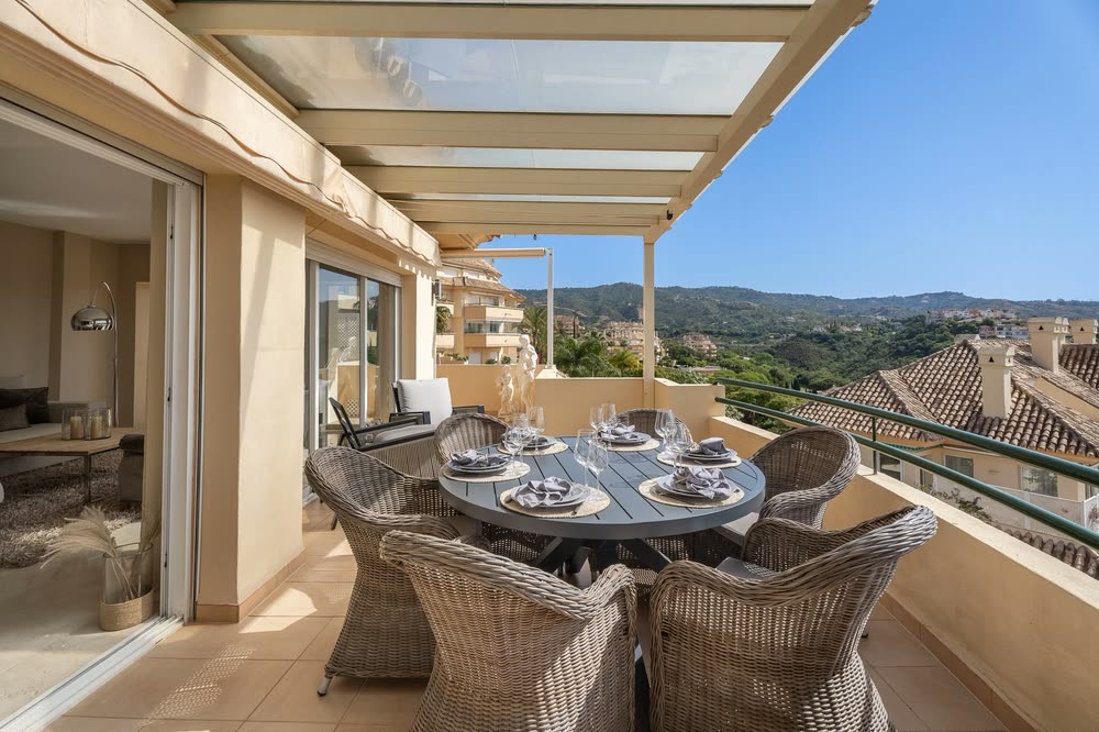 Terrace dining table under a pergola with views to the hills