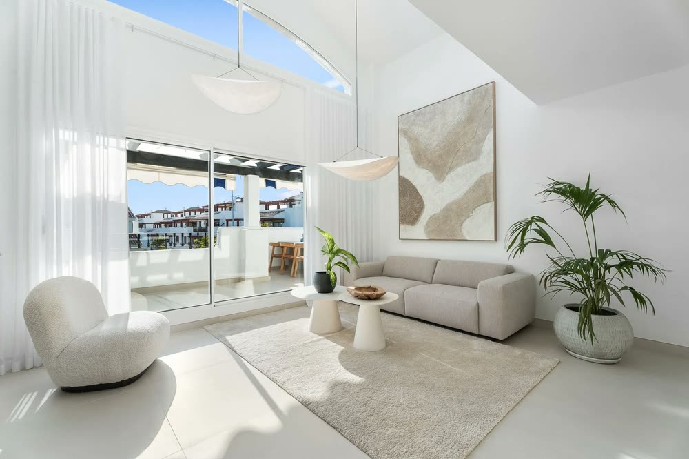 White living room with a sculptural armchair and terrace views