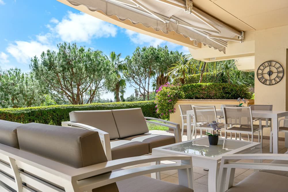 Garden terrace with outdoor sofas and pine trees