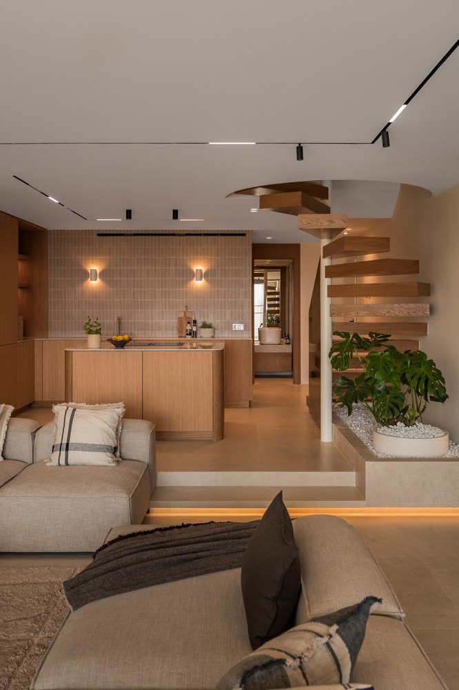 Oak kitchen with a tiled wall and a floating spiral staircase above a planted bed